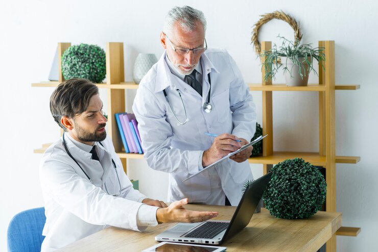 elderly doctor making notes while helping colleague 23 2147896168